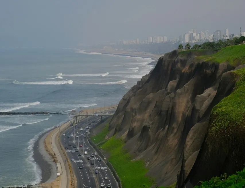 Acantilados verdes de Miraflores con vista al océano Pacífico y la Costa Verde de Lima, Perú, bajo una ligera neblina costera